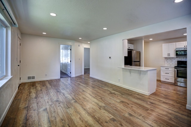 5320 N Ash St, Spokane, WA 99205 - unfurnished living room with wood finished floors, recessed lighting, and baseboards