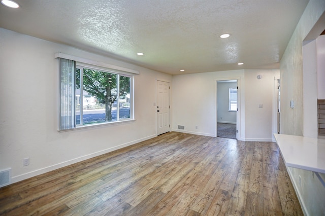 5320 N Ash St, Spokane, WA 99205 - unfurnished living room featuring recessed lighting, hardwood / wood-style flooring, a textured ceiling, and baseboards