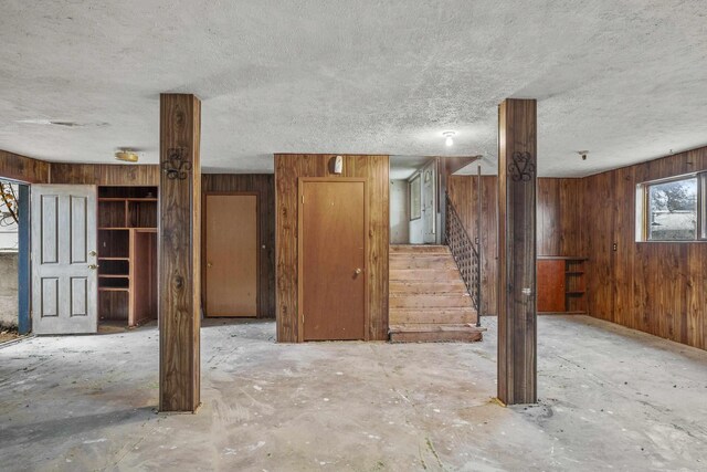 3707 E Olympic Ave, Spokane, WA 99217 - unfurnished living room featuring wooden walls, stairs, and a textured ceiling
