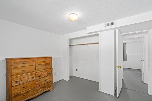 4615 E Russell Rd, Colbert, WA 99005 - bedroom featuring a closet, concrete flooring, and a textured ceiling