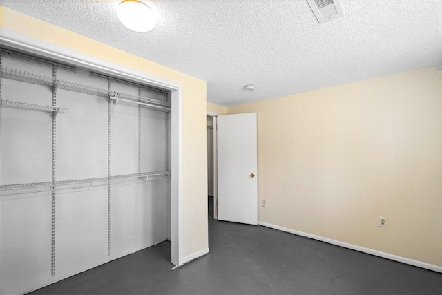 4615 E Russell Rd, Colbert, WA 99005 - unfurnished bedroom featuring a closet, a textured ceiling, baseboards, and concrete floors