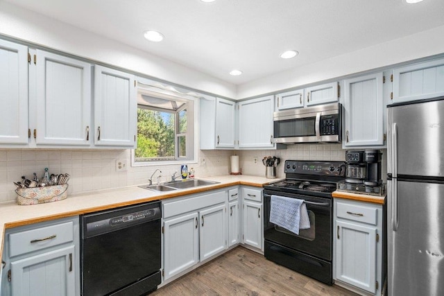 4615 E Russell Rd, Colbert, WA 99005 - kitchen with black appliances, a sink, light countertops, light wood finished floors, and decorative backsplash