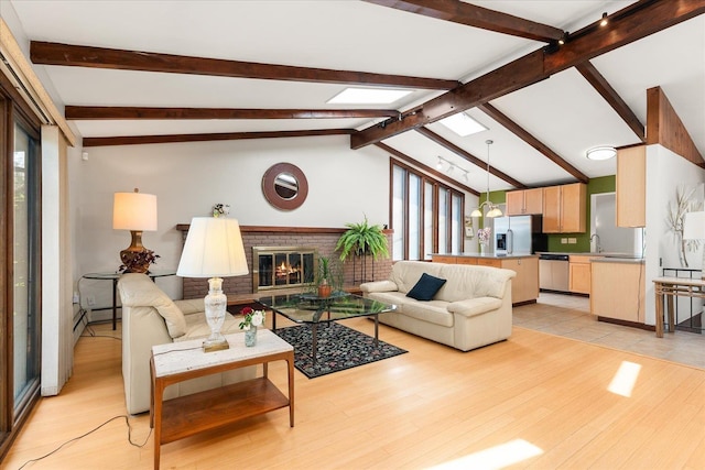 2111 E 34th Ave, Spokane, WA 99203 - living area with light wood-style flooring, a brick fireplace, a baseboard radiator, and a skylight