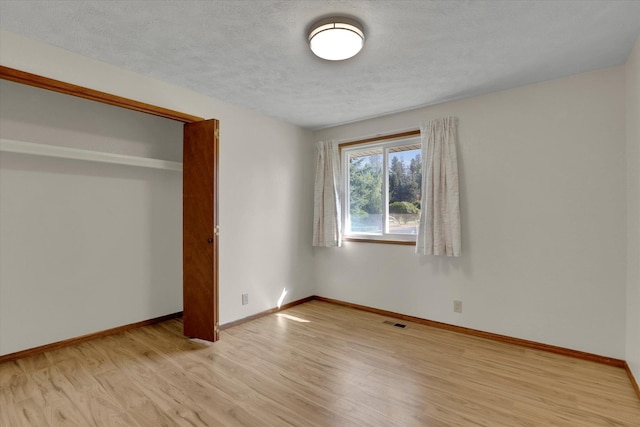 11619 N Roundup Rd, Mead, WA 99021 - unfurnished bedroom with light wood-type flooring, baseboards, and a textured ceiling
