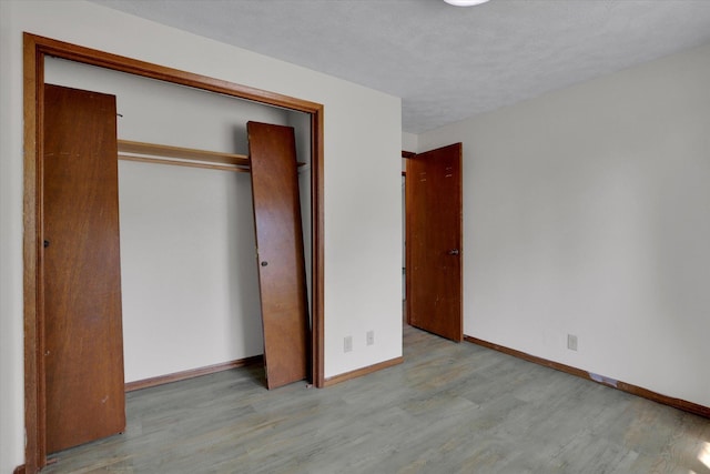 11619 N Roundup Rd, Mead, WA 99021 - unfurnished bedroom with wood finished floors, baseboards, a closet, and a textured ceiling