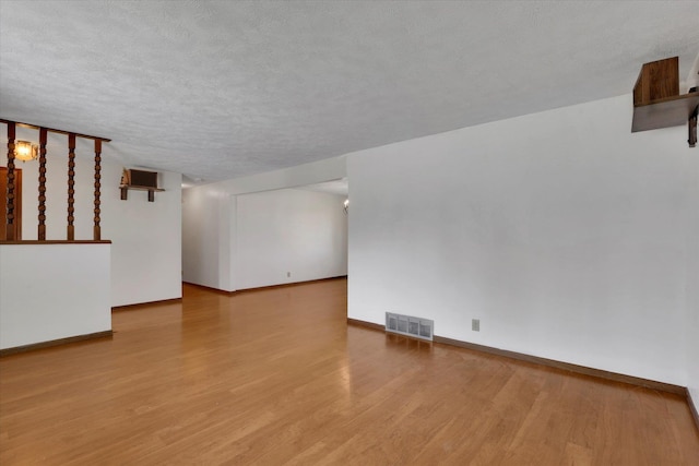 11619 N Roundup Rd, Mead, WA 99021 - unfurnished room featuring wood finished floors, baseboards, and a textured ceiling