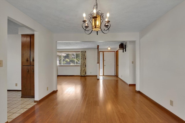 11619 N Roundup Rd, Mead, WA 99021 - spare room with light wood finished floors, a chandelier, and baseboards