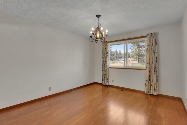 11619 N Roundup Rd, Mead, WA 99021 - empty room featuring a chandelier, light wood-type flooring, and baseboards