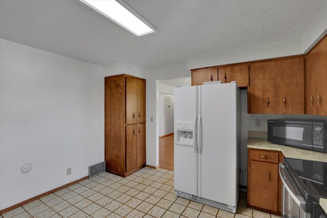 11619 N Roundup Rd, Mead, WA 99021 - kitchen featuring black microwave, white fridge with ice dispenser, electric stove, light countertops, and brown cabinetry