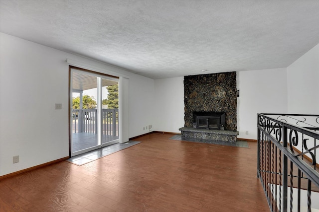11619 N Roundup Rd, Mead, WA 99021 - unfurnished living room with wood finished floors, a textured ceiling, baseboards, and a fireplace