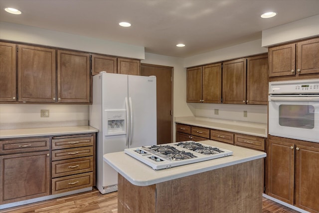 1815 E 64th Ave, Spokane, WA 99223 - kitchen featuring white appliances, light wood-style floors, light countertops, recessed lighting, and a center island
