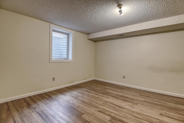 1815 E 64th Ave, Spokane, WA 99223 - basement with wood finished floors, a textured ceiling, and baseboards