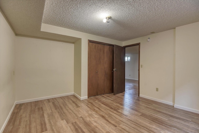 1815 E 64th Ave, Spokane, WA 99223 - unfurnished bedroom featuring light wood-type flooring, a textured ceiling, a closet, and baseboards