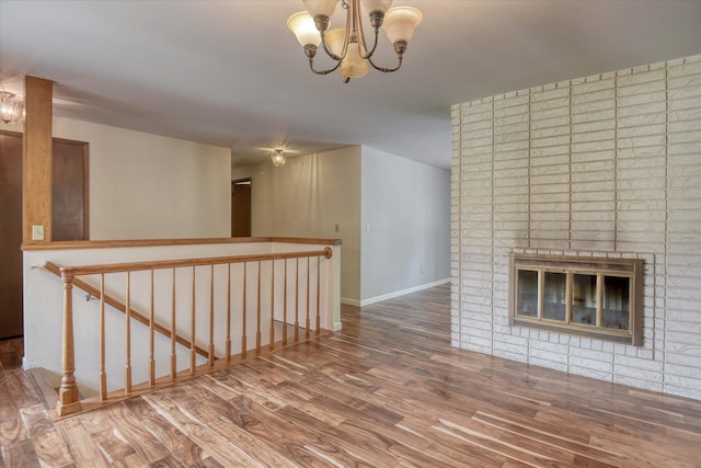 1815 E 64th Ave, Spokane, WA 99223 - hallway featuring an upstairs landing, wood finished floors, a chandelier, and baseboards