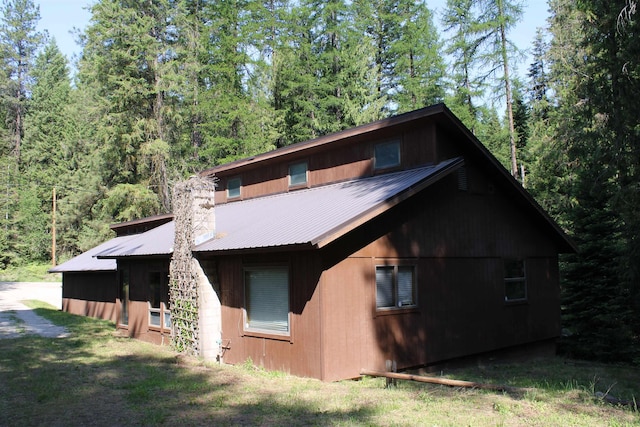 42604 Hatch Rd, Deer Park, WA 99006 - view of side of home with metal roof, a chimney, and a wooded view