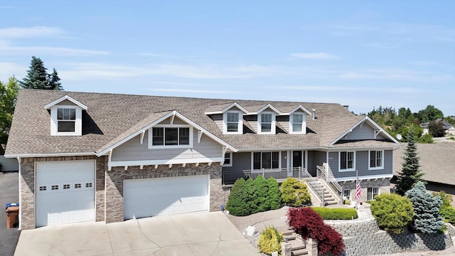 2306 W Rainier Ct, Spokane, WA 99208 - view of front of house with concrete driveway, covered porch, brick siding, a garage, and stairway