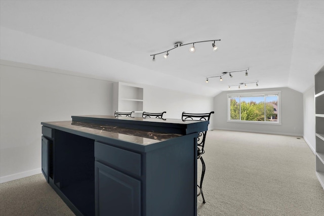 2306 W Rainier Ct, Spokane, WA 99208 - kitchen with open floor plan, light colored carpet, lofted ceiling, a kitchen breakfast bar, and baseboards