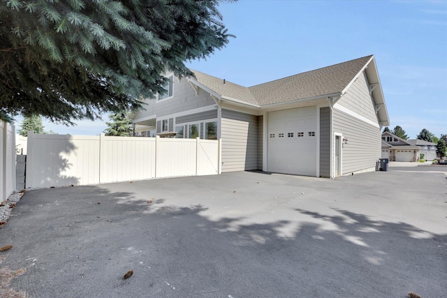 2306 W Rainier Ct, Spokane, WA 99208 - view of side of property featuring a shingled roof and an attached garage