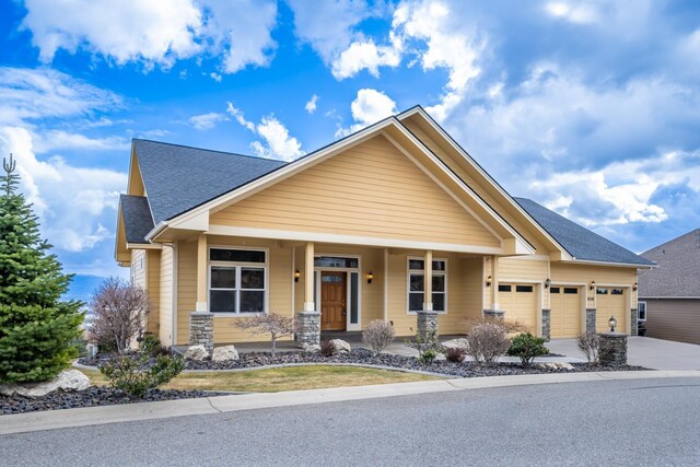 8518 E Black Oak Ln, Spokane, WA 99217 - craftsman house with roof with shingles, an attached garage, driveway, and a porch