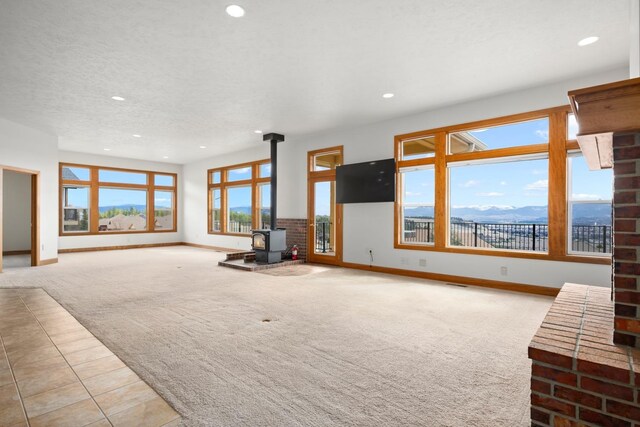 8518 E Black Oak Ln, Spokane, WA 99217 - unfurnished living room featuring carpet, baseboards, a wood stove, and recessed lighting