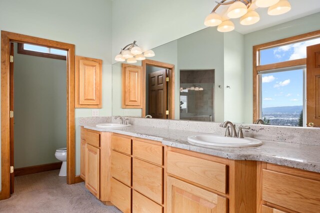 8518 E Black Oak Ln, Spokane, WA 99217 - bathroom with double vanity, toilet, a chandelier, and tiled shower