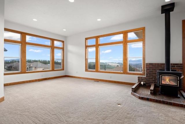 8518 E Black Oak Ln, Spokane, WA 99217 - unfurnished living room featuring a wood stove, baseboards, carpet flooring, and recessed lighting