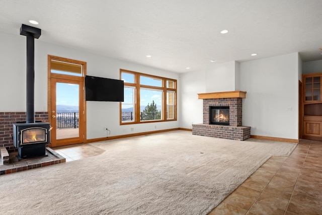 8518 E Black Oak Ln, Spokane, WA 99217 - unfurnished living room with a wood stove, healthy amount of natural light, a brick fireplace, recessed lighting, and carpet flooring
