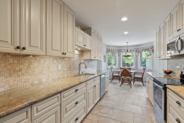 2203 W Strong Rd, Spokane, WA 99208 - kitchen featuring appliances with stainless steel finishes, a sink, cream cabinetry, recessed lighting, and decorative backsplash