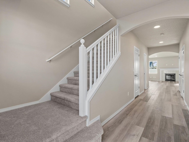 5112 N Silas Ln Unit 9/1Talent, Spokane Valley, WA 99216 - stairway with a tile fireplace, arched walkways, wood finished floors, baseboards, and recessed lighting