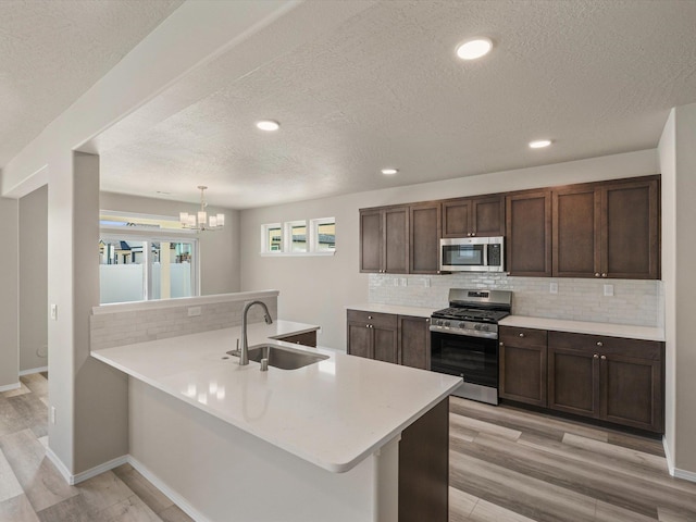 5112 N Silas Ln Unit 9/1Talent, Spokane Valley, WA 99216 - kitchen featuring appliances with stainless steel finishes, a sink, tasteful backsplash, light countertops, and a textured ceiling