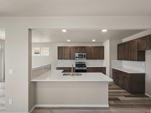 5112 N Silas Ln Unit 9/1Talent, Spokane Valley, WA 99216 - kitchen featuring stainless steel appliances, a sink, a peninsula, dark brown cabinetry, and recessed lighting