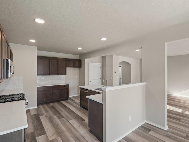 5112 N Silas Ln Unit 9/1Talent, Spokane Valley, WA 99216 - kitchen featuring appliances with stainless steel finishes, a sink, light wood-style floors, a textured ceiling, and dark brown cabinetry