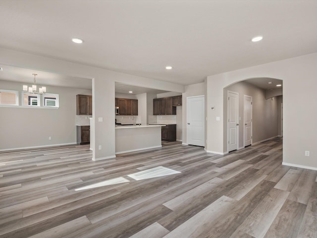 5112 N Silas Ln Unit 9/1Talent, Spokane Valley, WA 99216 - unfurnished living room featuring light wood-style flooring, arched walkways, recessed lighting, baseboards, and a chandelier