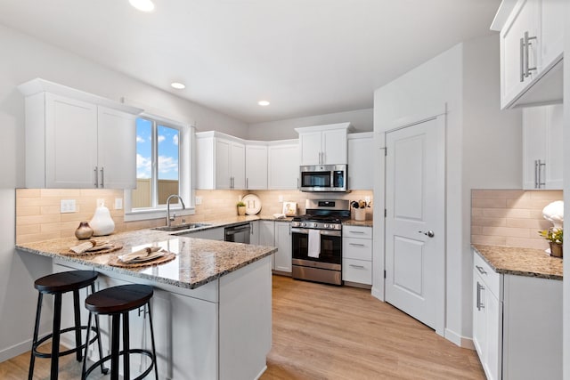 1624 W 68th Ave Unit 2/2Timberline, Spokane, WA 99224 - kitchen featuring stainless steel appliances, a peninsula, a sink, tasteful backsplash, and light stone countertops