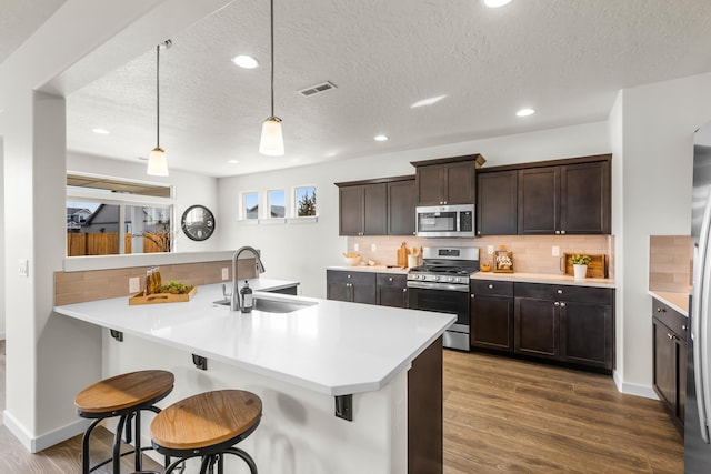 1638 W 68th Ave Unit 1/2Talent, Spokane, WA 99224 - kitchen with stainless steel appliances, a sink, a textured ceiling, tasteful backsplash, and dark wood-style flooring