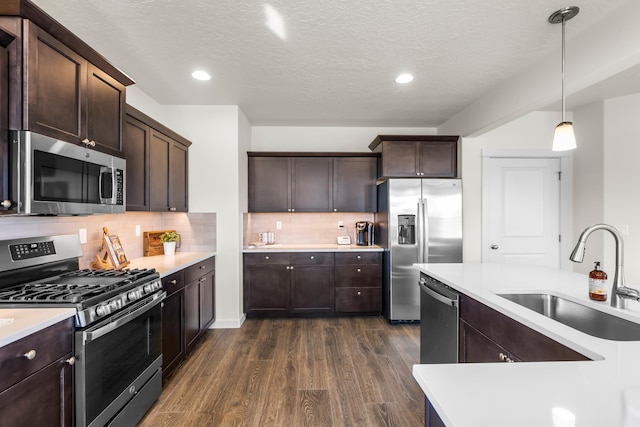 1638 W 68th Ave Unit 1/2Talent, Spokane, WA 99224 - kitchen featuring appliances with stainless steel finishes, a sink, light countertops, dark wood-style flooring, and dark brown cabinetry