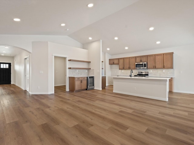 1438 W 67th Ave Lot 5Block 3, Orchard, Spokane, WA 99224 - kitchen with appliances with stainless steel finishes, wine cooler, arched walkways, brown cabinetry, and vaulted ceiling