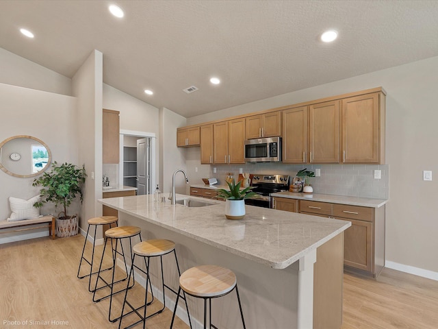 1438 W 67th Ave Lot 5Block 3, Orchard, Spokane, WA 99224 - kitchen featuring stainless steel appliances, a sink, light wood-type flooring, decorative backsplash, and light stone counters