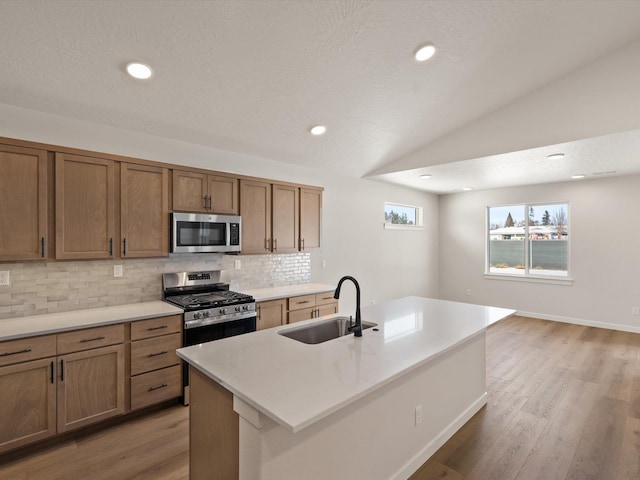 1438 W 67th Ave Lot 5Block 3, Orchard, Spokane, WA 99224 - kitchen featuring appliances with stainless steel finishes, a sink, decorative backsplash, light wood-style flooring, and vaulted ceiling