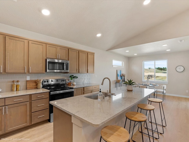 1438 W 67th Ave Lot 5Block 3, Orchard, Spokane, WA 99224 - kitchen with stainless steel appliances, light wood-style floors, a sink, a breakfast bar, and backsplash