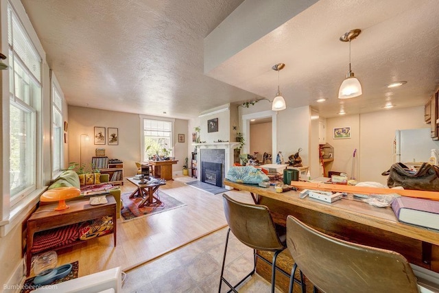 1611 W 9th Ave, Spokane, WA 99223 - kitchen with a textured ceiling, freestanding refrigerator, a fireplace, hanging light fixtures, and open floor plan