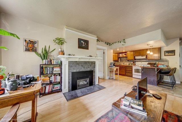 1611 W 9th Ave, Spokane, WA 99223 - living area featuring light wood-style floors, a fireplace, and a textured ceiling
