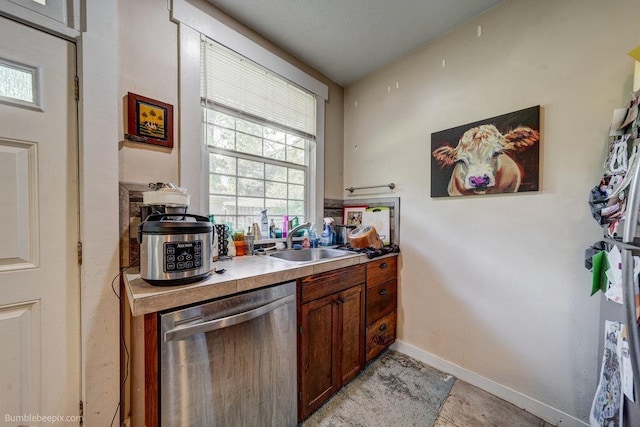 1611 W 9th Ave, Spokane, WA 99223 - kitchen with dishwasher, a sink, brown cabinetry, light countertops, and baseboards