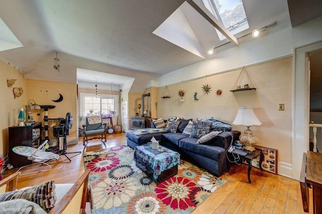 1611 W 9th Ave, Spokane, WA 99223 - living area with wood-type flooring, vaulted ceiling, a skylight, and baseboards
