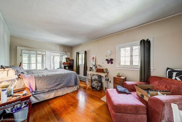 1611 W 9th Ave, Spokane, WA 99223 - bedroom featuring hardwood / wood-style flooring, ornamental molding, a textured ceiling, and a baseboard radiator