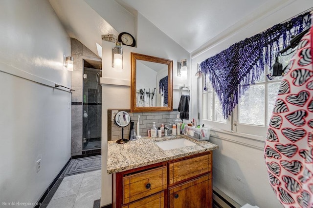 1611 W 9th Ave, Spokane, WA 99223 - full bath with a tile shower, vanity, vaulted ceiling, a baseboard heating unit, and backsplash