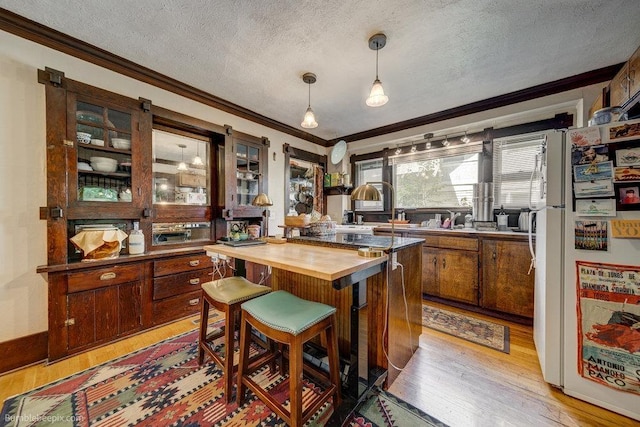 1621 W 9th Ave, Spokane, WA 99223 - kitchen with butcher block counters, freestanding refrigerator, ornamental molding, a textured ceiling, and light wood finished floors