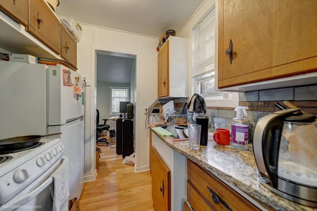 1621 W 9th Ave, Spokane, WA 99223 - kitchen with white range with electric cooktop, light wood-style flooring, brown cabinets, and light stone counters