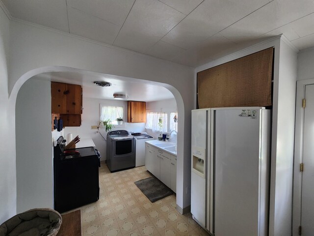 424 W Larch St, Newport, WA 99156 - kitchen with white fridge with ice dispenser, arched walkways, separate washer and dryer, light floors, and light countertops