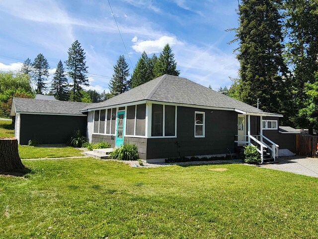 424 W Larch St, Newport, WA 99156 - view of front of property with roof with shingles, a sunroom, entry steps, and a front lawn